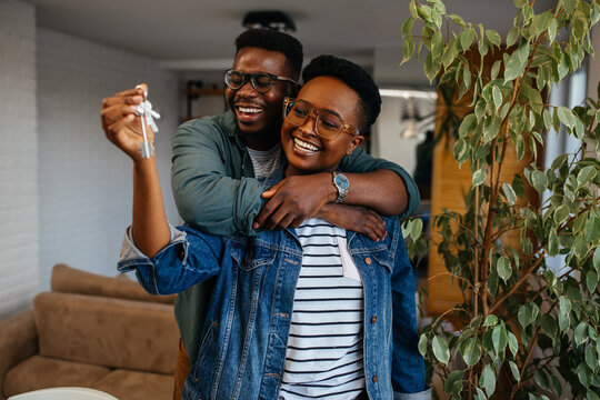 Couple cheerful home owners holding a key