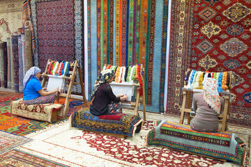 Woman hands weaving a handmade carpet
