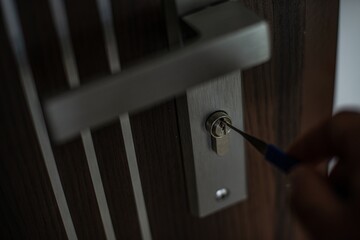 A burglar's hand with a lockpick. Burglary into an apartment or house.