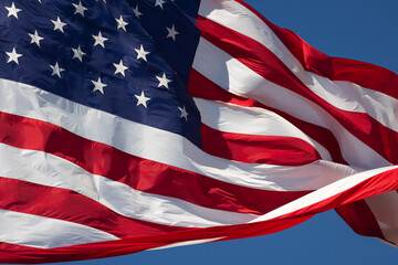 American Flag Waving In Wind Against a Deep Blue Sky.