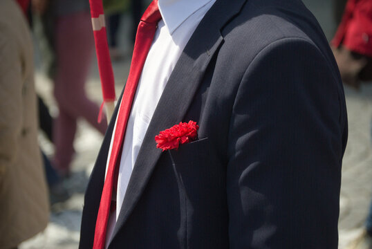 Pessoa com um fato preto vestido, camisa branca, gravata vermelha e um cravo vermelho no bolso do casaco, contesta&ccedil;&atilde;o dos cravos vermelhos, meio ambiente, revolu&ccedil;&atilde;o portuguesa