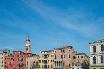 Fototapeta premium Venetian houses and tower under blue sky in Venice, Italy