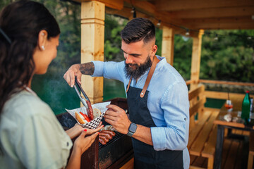 Lovely couple making burgers outdoors