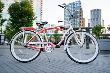 Fototapeta premium A vintage beach cruiser bike parked on a popular pedestrian pathway at East Village in downtown Calgary Alberta Canada on a summer evening.