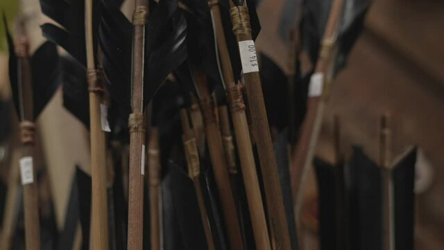 This tilt video shows a display of souvenir arrows for sale.