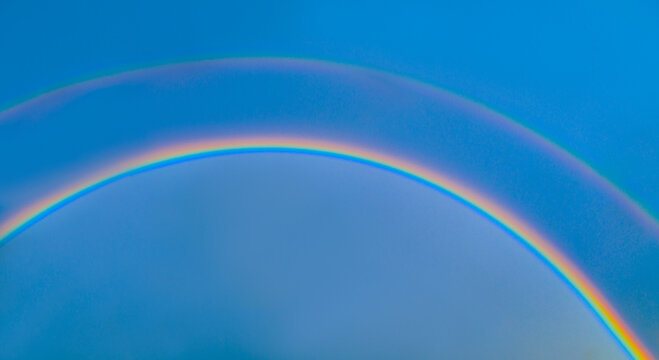 Double rainbow on blue sky