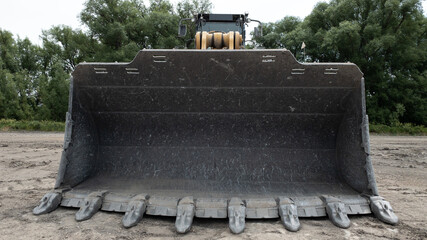 Quarry wheel loader shovel with big metal teeth seen in Longmont, Colorado, USA, on a sandy ground...