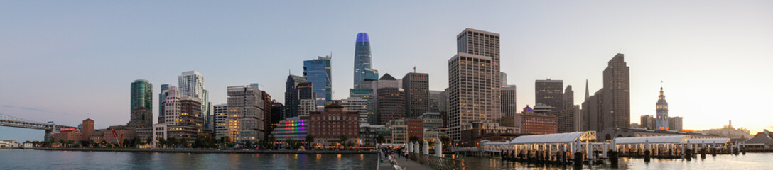 Naklejka premium Rainbow lights reflecting on water on The Embarcadero in San Francisco during Gay Pride month. 