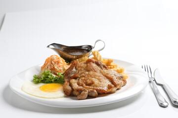 grilled golden bbq meat chicken cop pork cutlet beef steak with fried egg, French fries, coleslaw salad and black pepper sauce in pot western cuisine menu