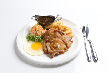 grilled golden bbq meat chicken cop pork cutlet beef steak with fried egg, French fries, coleslaw salad and black pepper sauce in pot western cuisine menu