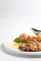 grilled golden bbq meat chicken cop pork cutlet beef steak with fried egg, French fries, coleslaw salad and black pepper sauce in pot western cuisine menu