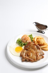 grilled golden bbq meat chicken cop pork cutlet beef steak with fried egg, French fries, coleslaw salad and black pepper sauce in pot western cuisine menu