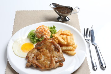 grilled golden bbq meat chicken cop pork cutlet beef steak with fried egg, French fries, coleslaw salad and black pepper sauce in pot western cuisine menu