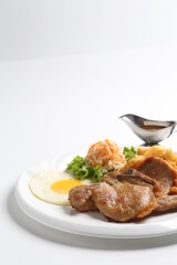 grilled golden bbq meat chicken cop pork cutlet beef steak with fried egg, French fries, coleslaw salad and black pepper sauce in pot western cuisine menu