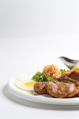 grilled golden bbq meat chicken cop pork cutlet beef steak with fried egg, French fries, coleslaw salad and black pepper sauce in pot western cuisine menu