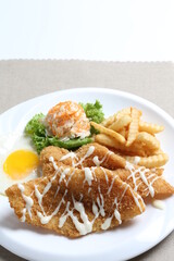 deep fried golden crispy fish fillet and chips with fried egg, French fries, coleslaw salad in tartar sauce western cuisine menu