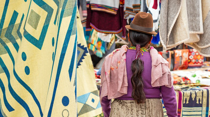 Indigenous Ecuadorian Otavalo woman in traditional clothing, hat and hairstyle on Otavalo local...
