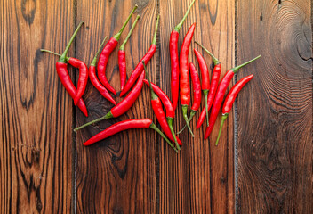 Red chili pepper pods on dark wooden background