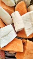 pieces of white cassava and orange pieces of red sweet potato, ready to be boiled on the stove. Traditional food from the tropics