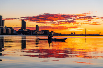 A sea kayaker crossing Toronto's Inner Harbour just as the rising sun breaks the horizon.