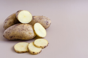 Potato tubers and half a potato on a colored background. Potatoes on a colored background of kopi space	