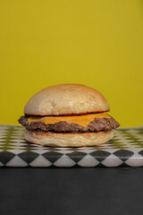 Simple cheeseburger on yellow background