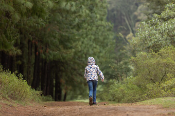 little girl running alone in the forest