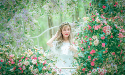Obraz na płótnie Canvas Portrait beautiful woman tourist posing happiness with smile ,she wearing a nice dress to travel in garden colorful flowers blooming for a summer vacation with beautiful flower garden background.
