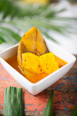 Sea bass in Tamarind Flavor Sour Soup Southern Thai Recipe with pineapple , thai food and vegetable in white bowl