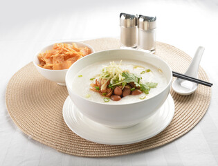 chef boiled Hong Kong teochew congee porridge with peanut, onion and cracker healthy halal vegan on white table restaurant asian cafe halal chinese banquet menu
