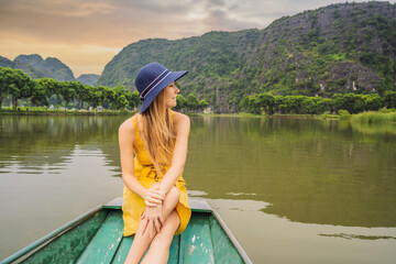Woman tourist in boat on the lake Tam Coc, Ninh Binh, Viet nam. It's is UNESCO World Heritage Site, renowned for its boat cave tours. It's Halong Bay on land of Vietnam. Vietnam reopens borders after