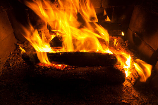 burning logs in the fire of a barbecue or stove or fireplace