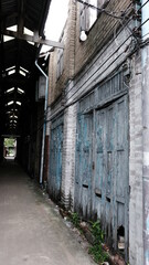 June 16 2021, Minburi, Thailand : Old wooden entrance door on facade of abandoned building in dark narrow alley an old town.