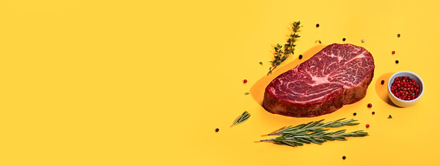 Fresh marbled beef rib eye steak and spices on yellow banner, trendy shadows
