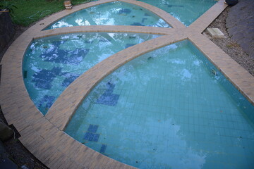Obraz na płótnie Canvas Modern swimming pool. children's pool. family pool with garden blue tiled floor for summer activities