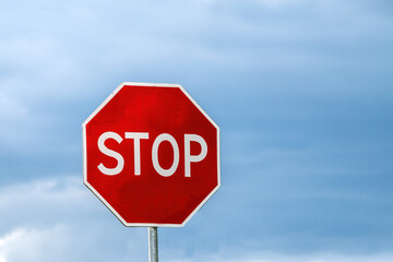 The traffic sign stop on the background clouds and blue sky, free space for texts.