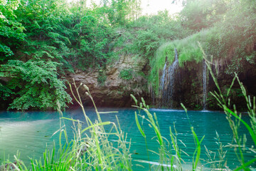 small beautiful waterfall with blue lake
