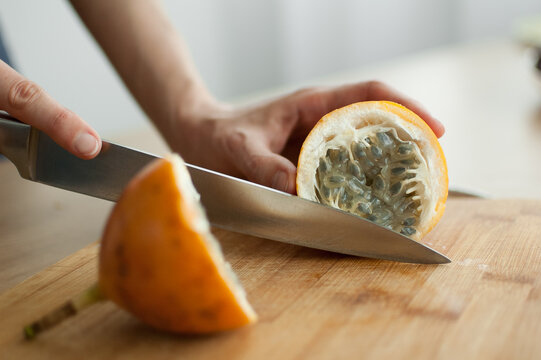 Fresh organic ripe granadilla or yellow passion fruit cut in half on a wooden board. Exotic fruits, healthy eating concept