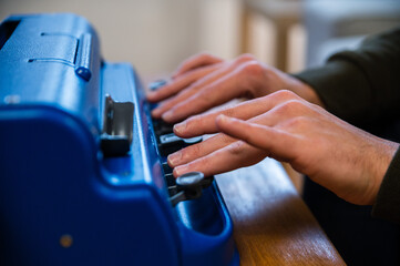 Blind man typing on typewriter with braille code