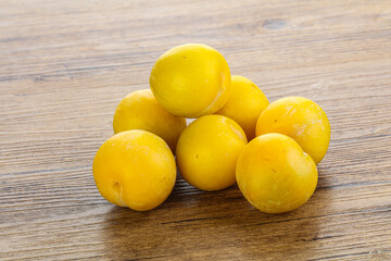 Ripe sweet yellow plum heap over background