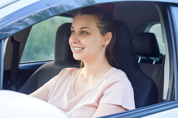 Beautiful smiling woman driver sitting in her car