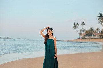 Fototapeta na wymiar Portrait of beautiful young woman in dress on the beach. Pretty girl on tropical beach. Freedom concept, holiday, beach, sky background.