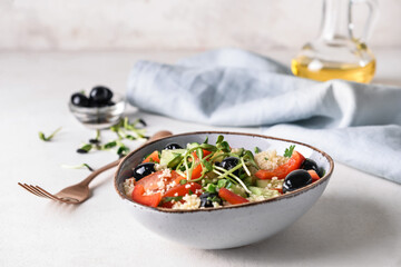 Bowl with couscous and vegetables on light background, closeup