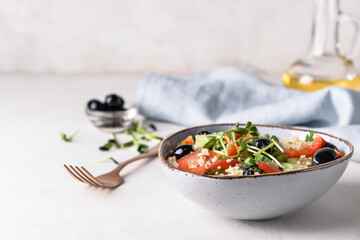 Bowl with couscous and vegetables on light background, closeup