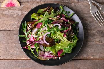 Plate with couscous and vegetables on wooden background