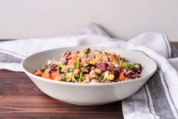 Bowl with couscous and vegetables on wooden background, closeup