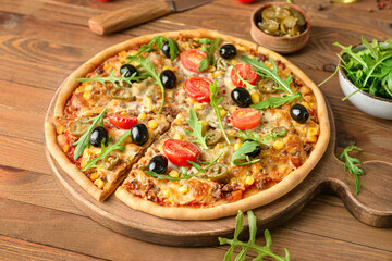 Board with tasty pizza on wooden background