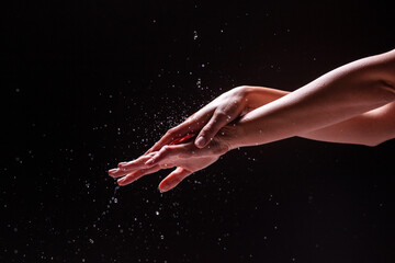 Crop hands of woman under splashing water