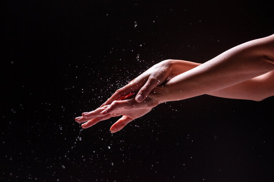 Crop hands of woman under splashing water