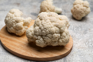 Board with cauliflower cabbage on grunge background, closeup